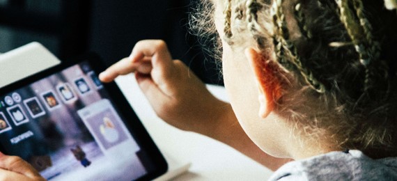 A child selecting apps on a tablet.