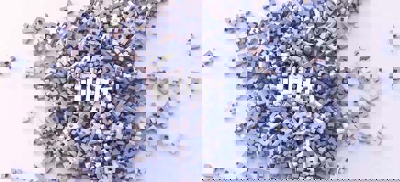 A pile of wooden question marks with a wooden letters spelling word what? on top of it.