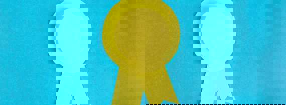 Yellow rosette made out of paper on a blue background