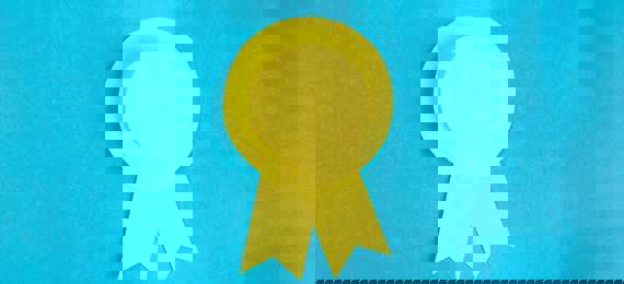 Yellow rosette made out of paper on a blue background