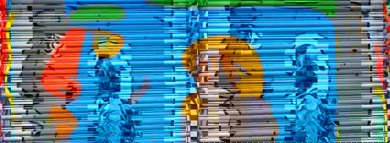 Image of person in front of painting of a face
