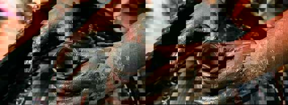 Two hands shaping a clay vase on a potter's wheel